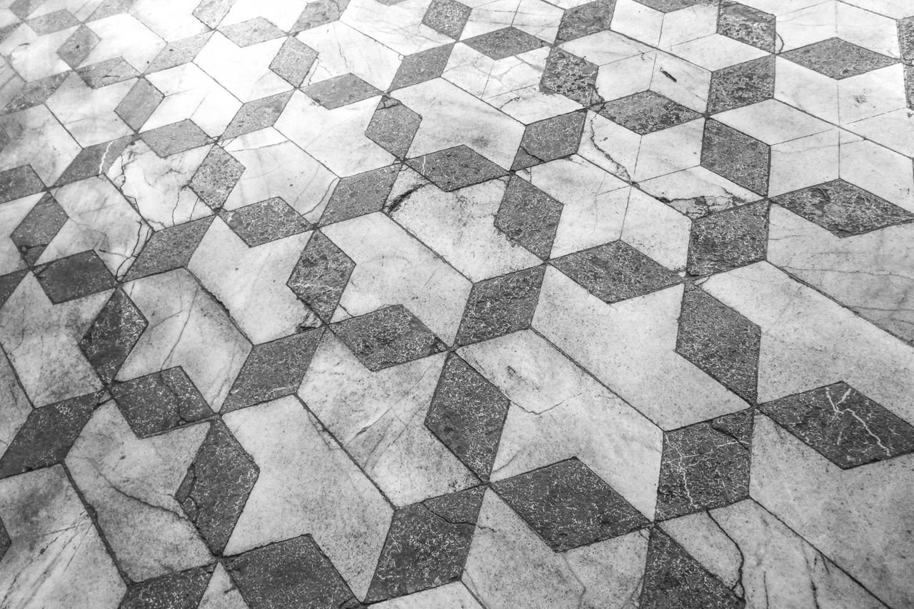 about-img Intricate marble tiles in a geometric 3D star pattern for a modern aesthetic.