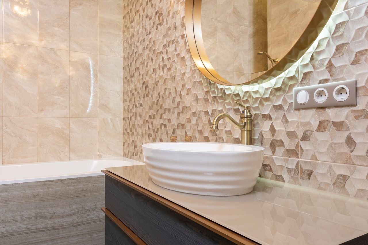 About Interior of bright bathroom with sink with tap on cabinet under mirror next to bathtub